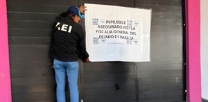 Persona poniendo un sello de clausura a un establecimiento de Oaxaca.