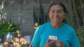 Una mujer adulta mayor sosteniendo en sus manos la tarjeta del Banco de Bienestar para adultos mayores