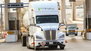 Tráiler avanzando en una caseta de cobro en una carretera.