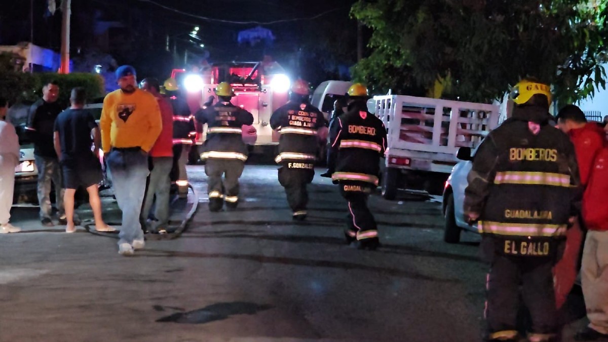 Elementos y camión de Protección Civil y Bomberos de Guadalajara con vecinos y automóviles alrededor durante una noche