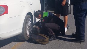 Se observan unos policías cargando a un joven que está en el piso.