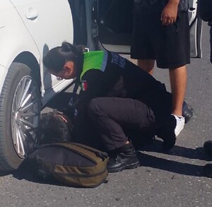 Se observan unos policías cargando a un joven que está en el piso.