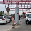 Se observa una ambulancia estacionada afuera de un edificio y un vehículo enfrente.