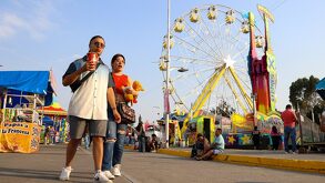 Personas caminando en las instalaciones de la Feria de Puebla.