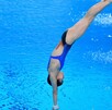 Clavadista ejecutando un clavado momento antes de entrar a la piscina.