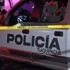 Vista lateral de una patrulla de la Policía Municipal de Tlaquepaque detrás de una cinta policiaca amarilla