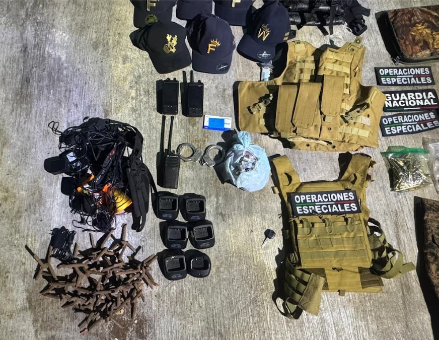 Armas, radios, esposas, chalecos tácticos y gorras con letreros de la Guardia Nacional esparcidos sobre el suelo