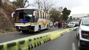 Camión de pasajeros dentro de un área acordonada por cinta policiaca con patrullas de la Policía de Tlaquepaque, oficiales, personas y vehículos alrededor