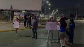 Se observa a un hombre y varias mujeres con cartelones en la mano en medio de la calle.