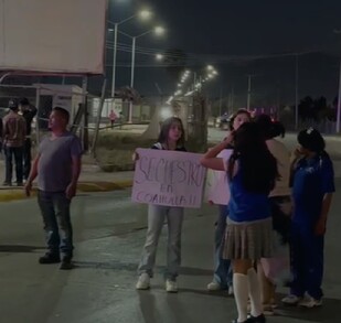 Se observa a un hombre y varias mujeres con cartelones en la mano en medio de la calle.