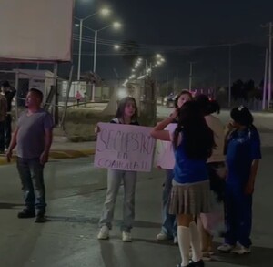 Se observa a un hombre y varias mujeres con cartelones en la mano en medio de la calle.