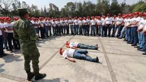 Se observan a jóvenes acostados en el piso, hay varios jóvenes parados vistiendo playera balnca y pantalón de mezclilla; hay un soldado.