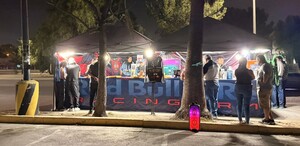 Se observan varias personas reunidas en la vía pública.