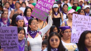 mujeres sostienen carteles en la marcha del 8 de marzo en puebla