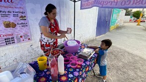 Angélica, madre de Héctor, trabajando vendiendo fresas con crema para poder recaudar para la deuda de las operaciones.