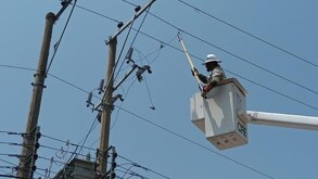 Trabajador de la CFE realizando trabajaos en un poste de luz con cableado eléctrico alrededor