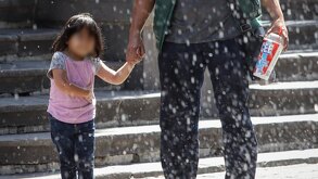 Hombre sostiene de la mano a una niña menor de edad mientras caminan por el centro de Puebla.