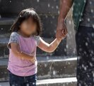 Hombre sostiene de la mano a una niña menor de edad mientras caminan por el centro de Puebla.