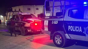 Se observa una patrulla, es de noche y hay varias personas.