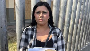 Mujer con camisa de cuadros gris y negro en papeles en mano