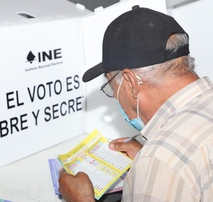 un hombre revisa una boleta electoral