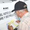un hombre revisa una boleta electoral