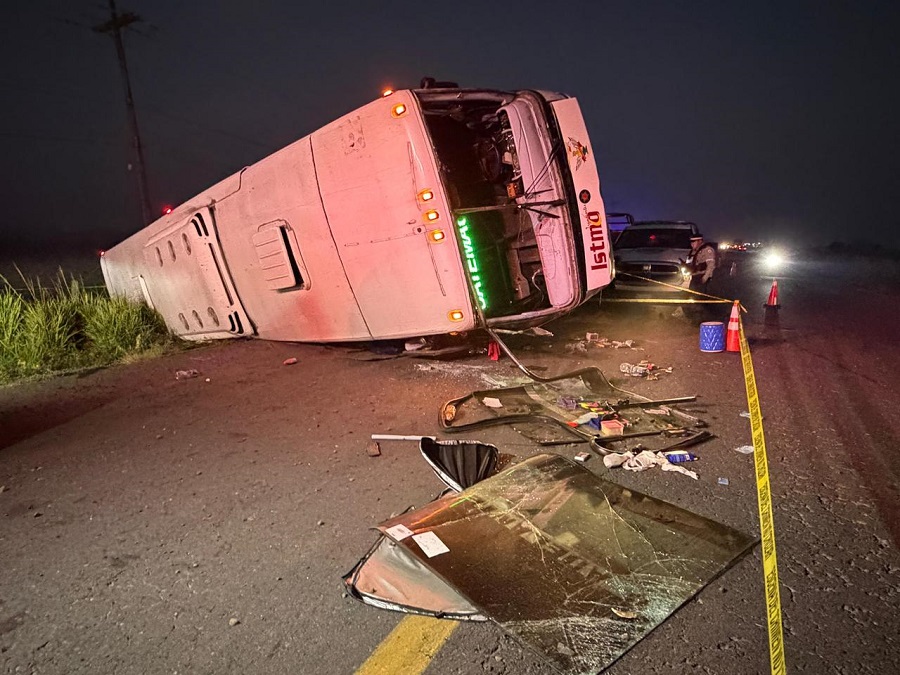 Autobús de pasajeros de la línea Istmo volcado en una carretera y con cristales rotos.