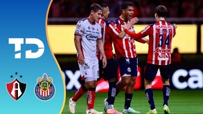 Jugadores de Chivas y Atlas se encuentran en la cancha durante el Clásico Tapatío; el gráfico incluye los escudos de ambos clubes y el logo de TD.