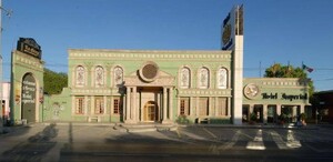 Se observa un edificio verde que tiene letras que dicen Hotel Imperial.