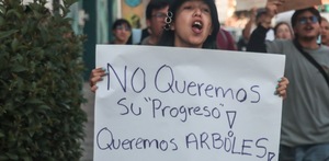 Ciudadana sostiene una pancarta en contra del Cablebús en Puebla