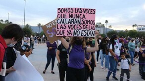 Mujer con pancarta y paliacate en color morado