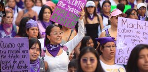 mujeres sostienen carteles en la marcha del 8 de marzo en puebla