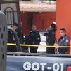 Oficiales de la Policía Municipal de Zapopan al interior de una casa naranja con portón negro y una patrulla estacionada afuera