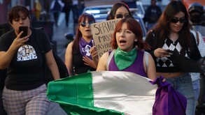 Mujeres marchan con una bandera durante una manifestación en Puebla.