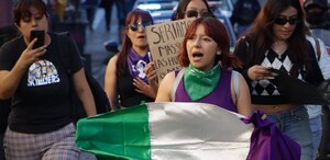 Mujeres marchan con una bandera durante una manifestación en Puebla.