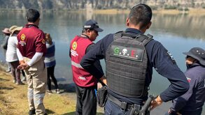 Policías junto a una laguna para rescatar el cuerpo de una mujer ahogada.