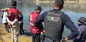 Policías junto a una laguna para rescatar el cuerpo de una mujer ahogada.