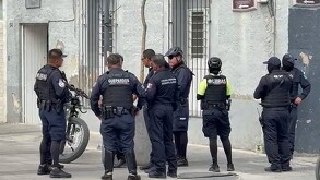 Oficiales de la Policía de Guadalajara y Grupo Guepardos reunidos afuera de un edificio gris con una bicicleta a un costado
