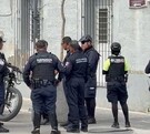 Oficiales de la Policía de Guadalajara y Grupo Guepardos reunidos afuera de un edificio gris con una bicicleta a un costado