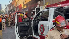 Camión y oficiales de Protección Civil y Bomberos desplegados en calles del centro de Guadalajara afuera de tiendas comerciales