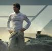 Brad Pitt con un traje de piloto de carreras frente a un auto de la Fórmula 1 y el logotipo de la F1