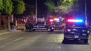 Varias patrullas de la Policía Municipal de Guadalajara con oficiales parados alrededor de una motocicleta tumbada en el suelo en un área acordonada