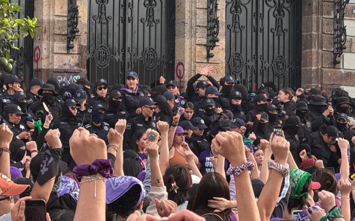 Mujeres y policías dentro dle marco 8M