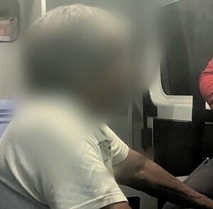 Se observa a un hombre de canas y con rostro con blur, sentado en una ambulancia, siendo atendido.