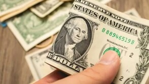 Mano sujetando un dólar en México.