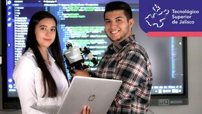 Una mujer con una bata blanca sosteniendo una laptop marca HP y un hombre sosteniendo un robot blanco, ambos viendo a la cámara mientras sonríen