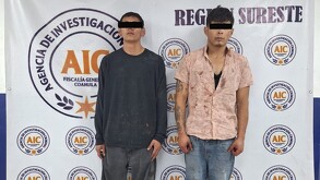 Se observa a dos hombres con ojos tapados con cintilla negra, están parados.