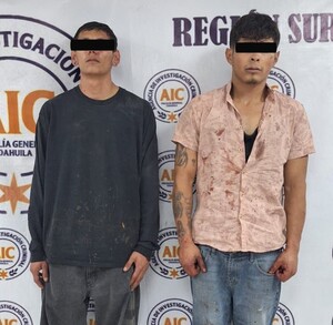 Se observa a dos hombres con ojos tapados con cintilla negra, están parados.