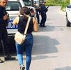 Mujer camina junto a una patrulla de policía de Veracruz estacionada, afuera de una vivienda.