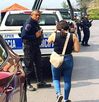 Mujer camina junto a una patrulla de policía de Veracruz estacionada, afuera de una vivienda.